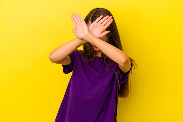 Jeune femme caucasienne isolée sur fond jaune en gardant les deux bras croisés, concept de déni.