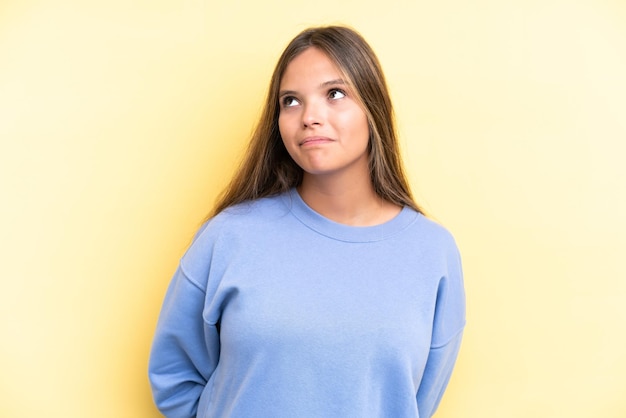 Jeune femme caucasienne isolée sur fond jaune et levant