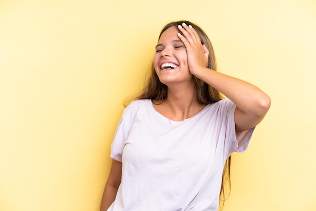 Jeune femme caucasienne isolée sur fond jaune souriant beaucoup