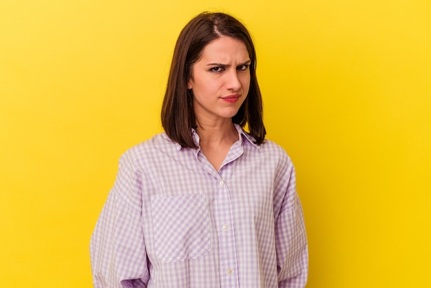 Jeune femme caucasienne isolée sur fond jaune, visage triste et sérieux, se sentant misérable et mécontent.