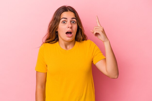 Jeune femme caucasienne isolée sur fond rose ayant une bonne idée, concept de créativité.