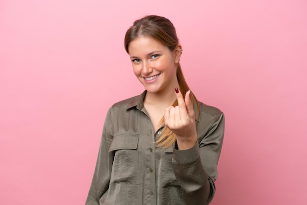 Jeune femme caucasienne isolée sur fond rose faisant un geste d'argent