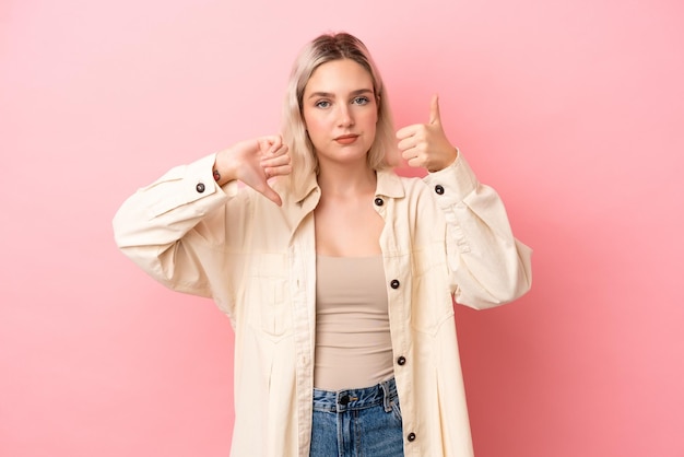 Jeune femme caucasienne isolée sur fond rose faisant signe bonmauvais Indécis entre oui ou non