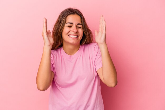 Jeune femme caucasienne isolée sur fond rose joyeux riant beaucoup. Notion de bonheur.