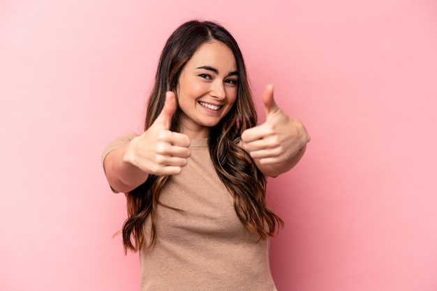 Jeune femme caucasienne isolée sur fond rose levant les deux pouces vers le haut souriant et confiant