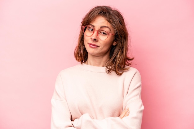 Jeune femme caucasienne isolée sur fond rose malheureuse regardant à huis clos avec une expression sarcastique