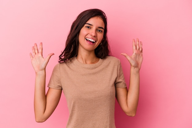 Jeune femme caucasienne isolée sur fond rose montrant le numéro dix avec les mains.