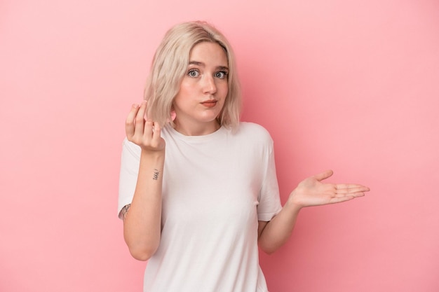 Jeune femme caucasienne isolée sur fond rose montrant qu'elle n'a pas d'argent