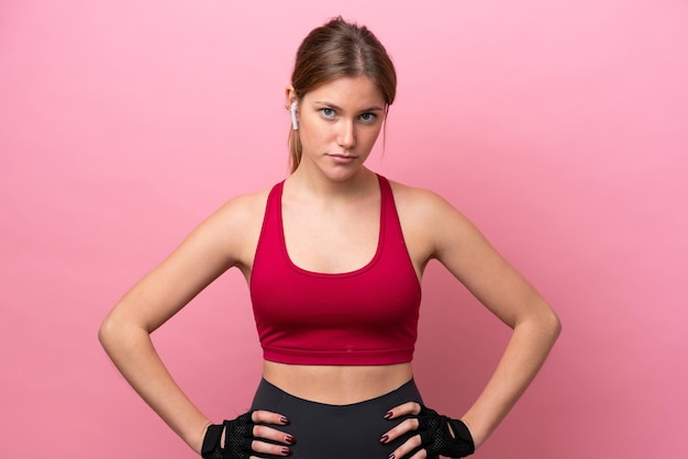 Jeune femme caucasienne isolée sur fond rose posant avec les bras à la hanche