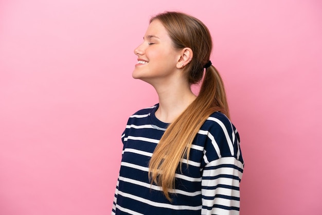 Photo jeune femme caucasienne isolée sur fond rose riant en position latérale