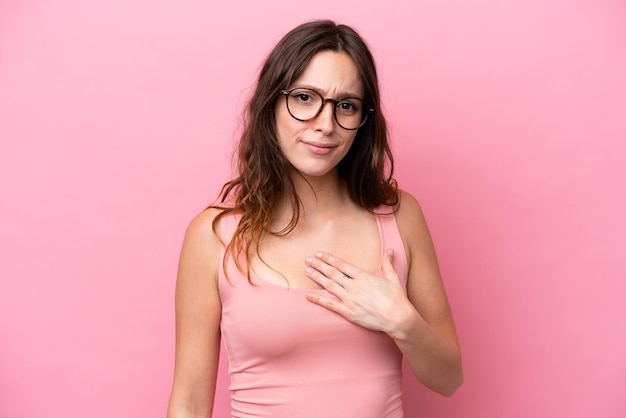 Photo une jeune femme caucasienne isolée sur un fond rose se montrant du doigt