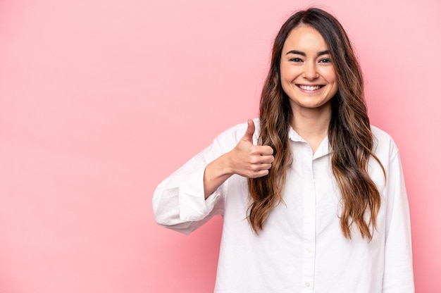 Jeune femme caucasienne isolée sur fond rose souriant et levant le pouce vers le haut