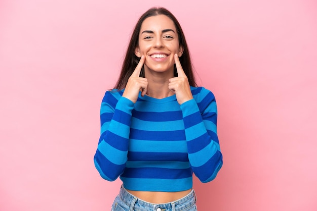 Jeune femme caucasienne isolée sur fond rose souriante avec une expression heureuse et agréable