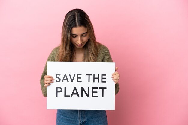 Jeune femme caucasienne isolée sur fond rose tenant une pancarte avec texte Save the Planet
