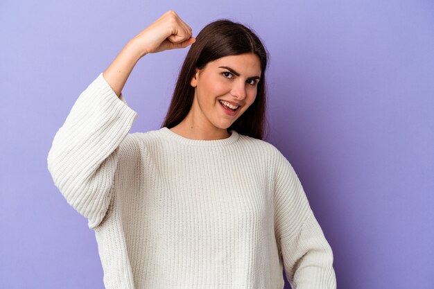 Jeune femme caucasienne isolée sur fond violet acclamant insouciante et excitée. Notion de victoire.