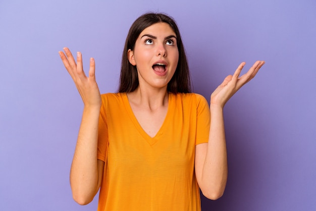 Jeune femme caucasienne isolée sur fond violet criant vers le ciel, levant les yeux, frustrée.