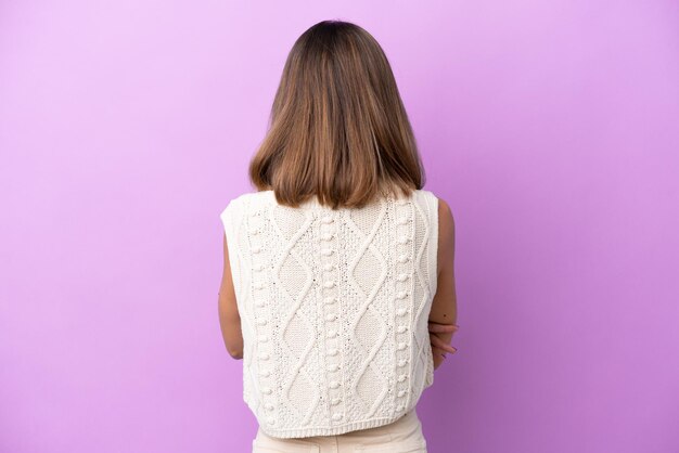 Jeune femme caucasienne isolée sur fond violet en position arrière