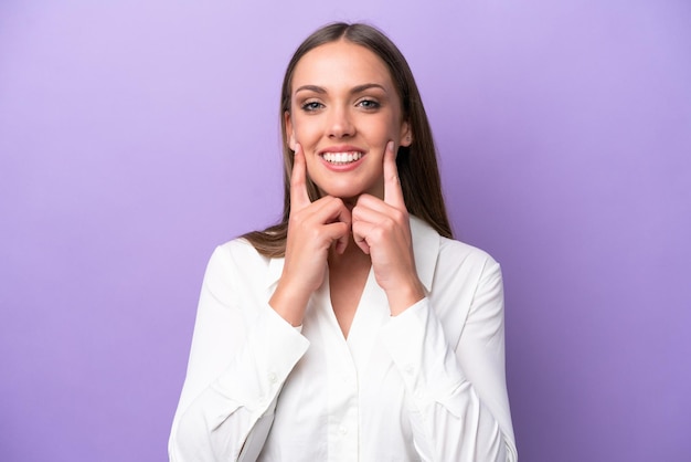 Jeune femme caucasienne isolée sur fond violet souriant avec une expression heureuse et agréable