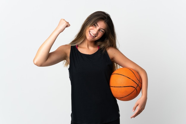 Jeune femme caucasienne isolée jouant au basket-ball et fière de lui-même