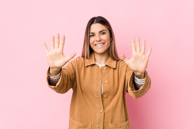 Jeune femme caucasienne isolée montrant le numéro dix avec les mains.