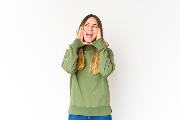 Jeune femme caucasienne isolée sur un mur blanc criant excité à l'avant.