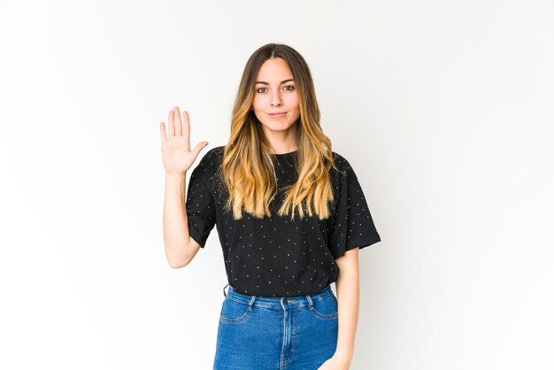 Jeune femme caucasienne isolée sur un mur blanc souriant joyeux montrant le numéro cinq avec les doigts.