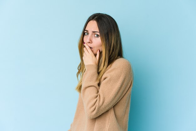 Jeune femme caucasienne isolée sur un mur bleu effrayé et effrayé.