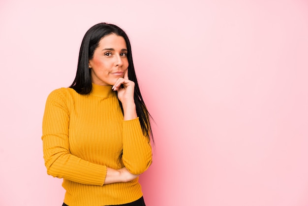 Jeune femme caucasienne isolée sur un mur rose détendu penser à quelque chose en regardant un espace copie.