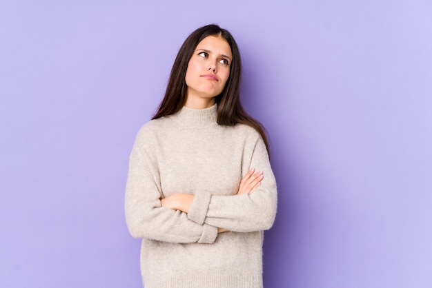 Jeune femme caucasienne isolée sur mur violet fatigué d'une tâche répétitive.