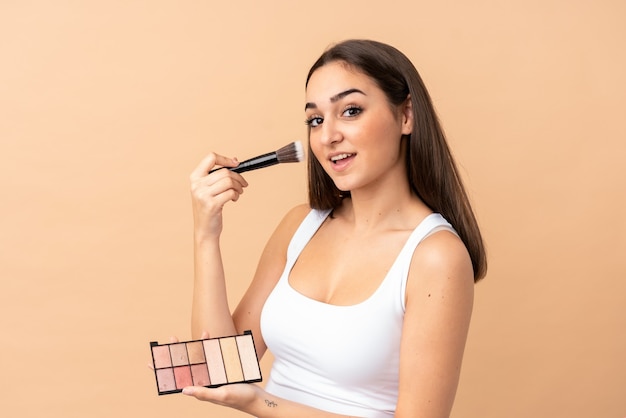 Jeune femme caucasienne isolée avec palette de maquillage