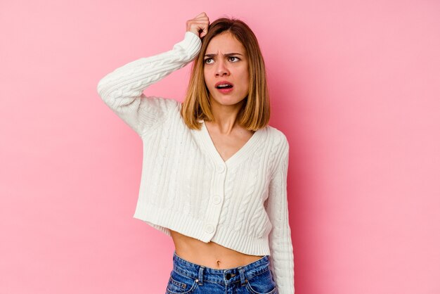 Jeune femme caucasienne isolée sur rose étant choquée, elle s'est souvenue d'une réunion importante.