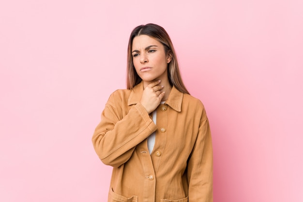 Jeune femme caucasienne isolée souffre de douleurs à la gorge en raison d'un virus ou d'une infection.