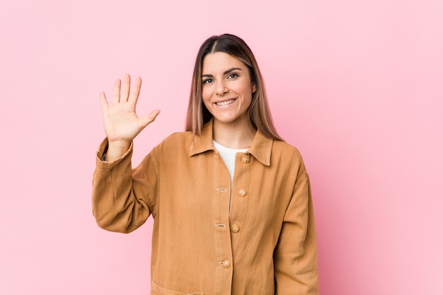 Jeune femme caucasienne isolée souriant joyeux montrant le numéro cinq avec les doigts.