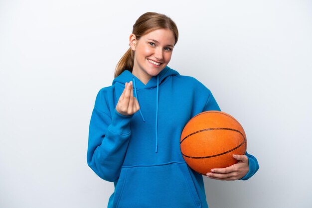 Jeune femme caucasienne jouant au basket isolé sur fond blanc faisant un geste d'argent