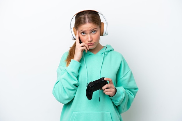 Jeune femme caucasienne jouant avec un contrôleur de jeu vidéo isolé sur fond blanc en pensant à une idée