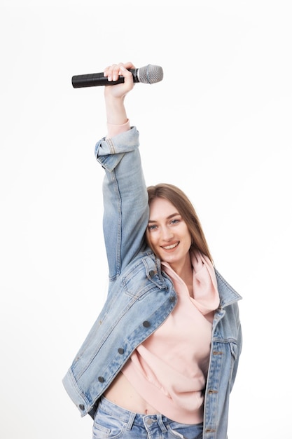 Jeune femme caucasienne joyeuse tenant un microphone isolé sur fond blanc