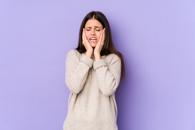 Jeune femme caucasienne sur mur violet pleurnicher et pleurer inconsolablement.