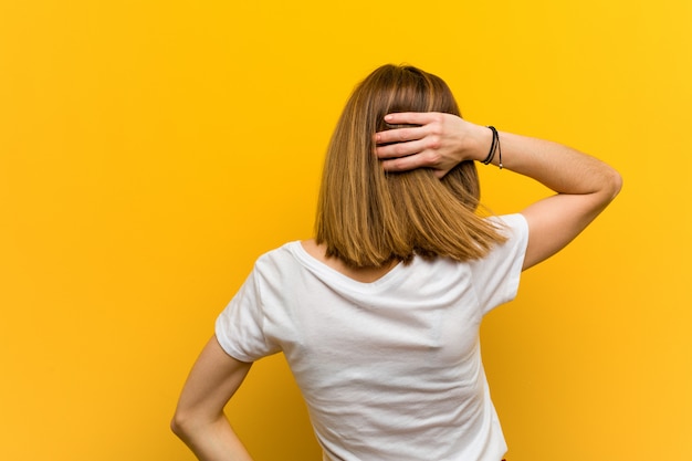 Jeune femme caucasienne naturelle par derrière en pensant à quelque chose.