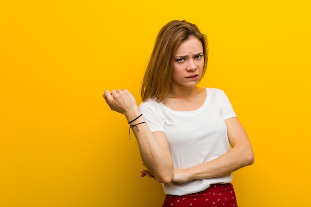 Jeune femme caucasienne naturelle, touchant la tête arrière, penser et faire un choix.