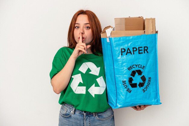 Jeune femme caucasienne papier recyclé isolé sur fond blanc gardant un secret ou demandant le silence.