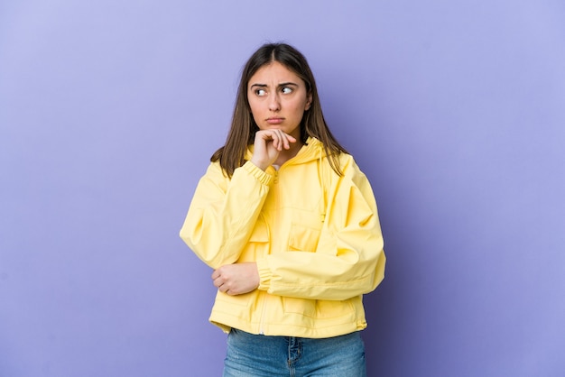 Jeune femme caucasienne pensant et levant les yeux, réfléchissant, contemplant, ayant un fantasme.