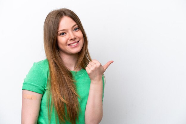 Jeune femme caucasienne portant un pansement isolé sur fond blanc pointant vers le côté pour présenter un produit