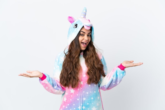 Jeune femme caucasienne portant un pyjama de licorne isolé sur fond blanc avec une expression faciale choquée