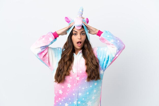 Jeune femme caucasienne portant un pyjama de licorne isolé sur fond blanc avec une expression de surprise