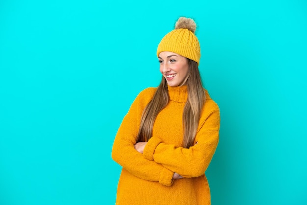 Jeune femme caucasienne portant une veste d'hiver isolée sur fond bleu heureuse et souriante