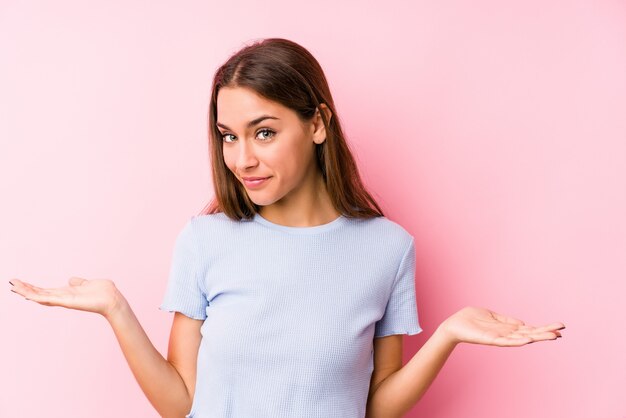 Jeune femme caucasienne portant un vêtement de ski isolé montrant une expression bienvenue.