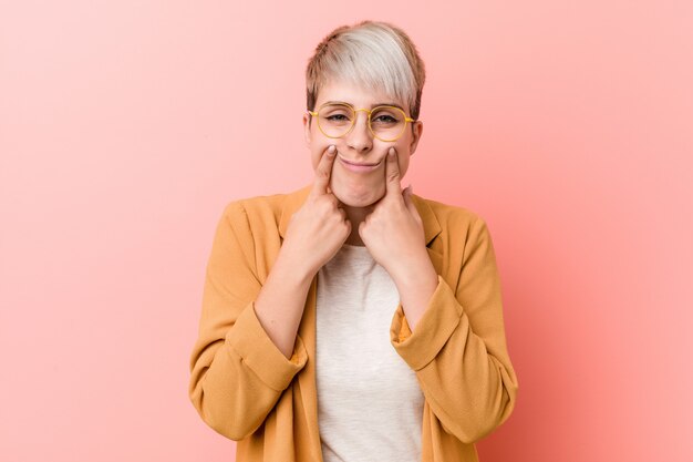 Jeune femme caucasienne portant un vêtement de travail décontracté doutant entre deux options.