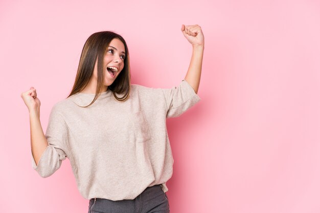 Jeune femme caucasienne posant isolé levant le poing après une victoire, concept gagnant.