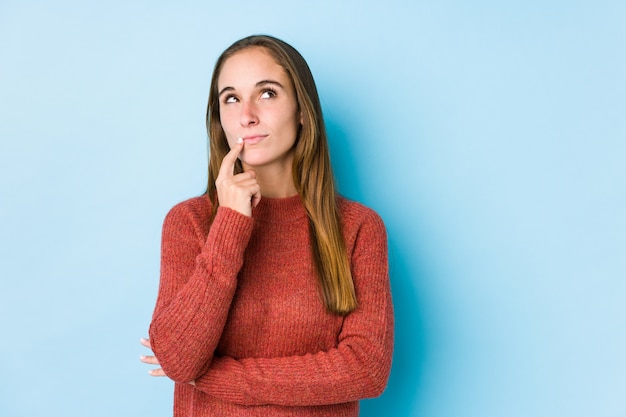 Jeune femme caucasienne posant isolé à la recherche sur le côté avec une expression douteuse et sceptique.