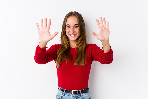 Jeune femme caucasienne posant montrant le numéro dix avec les mains.